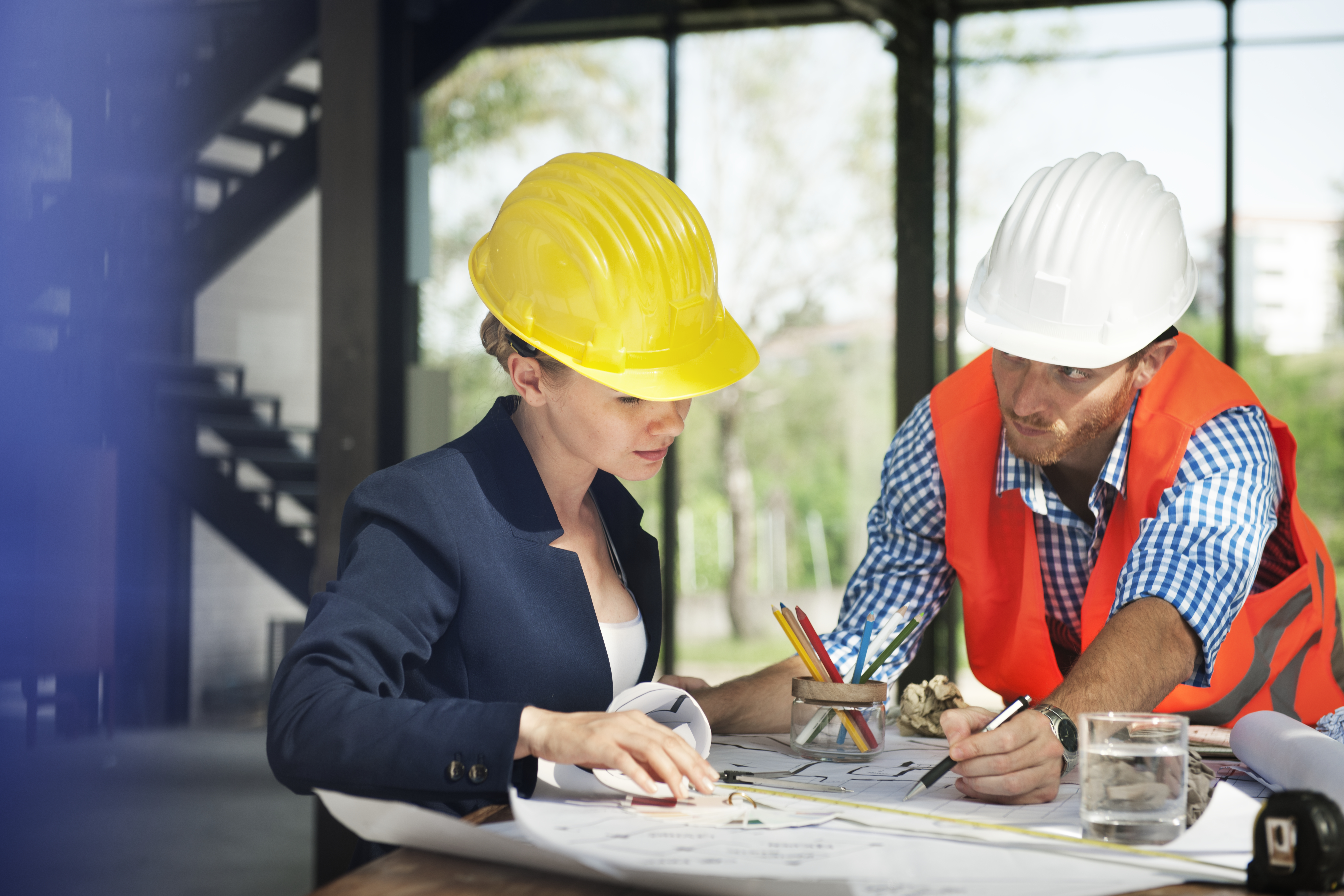 Deux employés dans le bâtiment, qui regarde un plan 