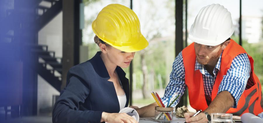 Deux employés dans le bâtiment, qui regarde un plan 